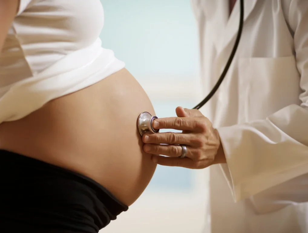聴診器で妊婦のお腹を診察する医療者